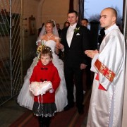 na fotografii ślubnej para młoda wchodzi do kościoła