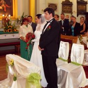 fotografia ślubna przedstawiająca państwa młodych stojących w kościele